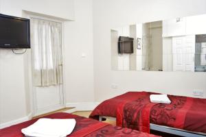 a room with two beds and a mirror at The Dharma Lodge in Enfield