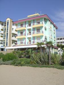 budynek na plaży z palmami przed nim w obiekcie Hotel Royal Garnì w Caorle