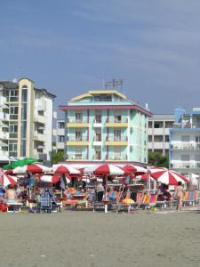 un grupo de tumbonas y sombrillas en la playa en Hotel Royal Garnì, en Caorle