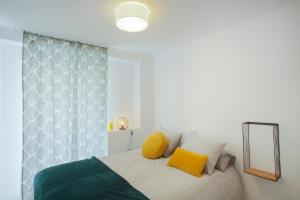 Un dormitorio con una cama con almohadas amarillas y un espejo. en Valencia Beach Marina, en Valencia