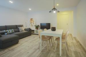 sala de estar con sofá y mesa con sillas en Apartment Meraki Valencia, en Valencia