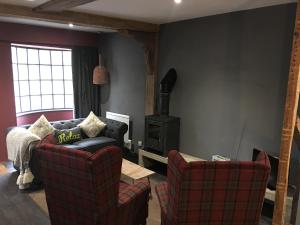 a living room with two chairs and a stove at Square House Bildeston High street in Ipswich