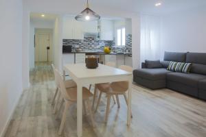 Una cocina y una sala de estar con una mesa y sillas blancas. en Valencia Beach Marina, en Valencia