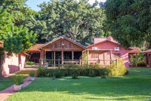 a house in a yard with a green lawn at Eco Resort Foz do Marinheiro in São João do Marinheiro