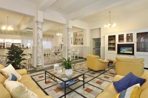 un soggiorno con divani gialli e tavolo di Hotel Nettuno a Marina di Pietrasanta