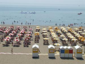 una playa con muchas sombrillas y gente en la playa en Hotel Royal Garnì, en Caorle