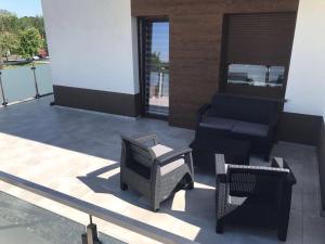 a patio with chairs and a chair and a couch at Apartamenty Platan Opieszyn in Września