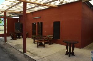 een groep tafels en banken in een gebouw bij El Refugio in Yala