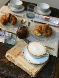 a table with plates of pastries and a cup of coffee at BLQ 01boutique B&B in Bologna
