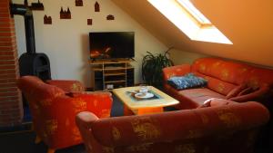 sala de estar con muebles de color naranja y TV de pantalla plana. en Ferienwohnung Familie Hübner en Lübeck