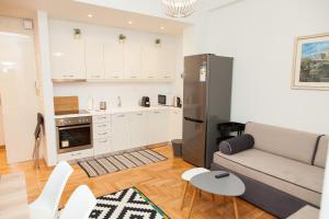 a kitchen and living room with a couch and a refrigerator at Luxury Apartment In Central Kolonaki in Athens