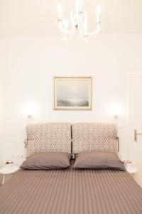 a bed in a white room with a picture on the wall at Luxury Apartment In Central Kolonaki in Athens