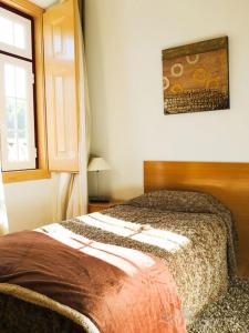 a bedroom with a bed and a window at Alojamento Cesarini in Montijo
