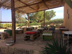 a patio with tables and benches and a pavilion at Agriturismo biologico 'A Lanterna in Marina di Monasterace +58 photos