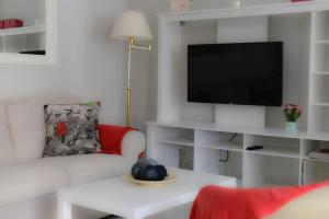 ein Wohnzimmer mit einem Sofa und einem TV in der Unterkunft Casa Apolo in Mogán