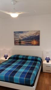 a bed in a room with a painting on the wall at LE COLONIE Apartments in Porto Cesareo