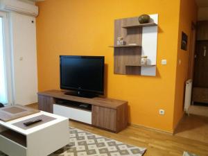a living room with a flat screen tv on a table at The Orange Apartment in Skopje