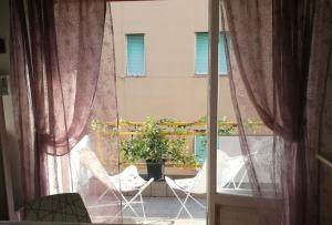 a window with two chairs and a potted plant on a balcony at Costaguta Apartment in Rapallo +8 photos