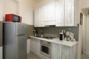 a kitchen with white cabinets and a white refrigerator at Filarmonico12 in Verona