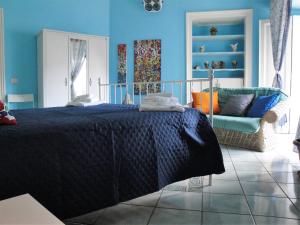 Dormitorio azul con cama y sofá en Garibaldi Holiday House en Nápoles