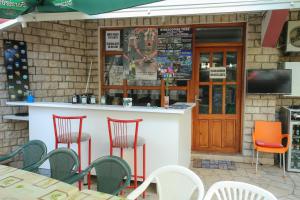 a bar with red chairs in front of a restaurant at Guesthouse Adi in Mostar