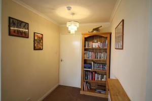 a hallway with a book shelf filled with books at Howgill in Windermere