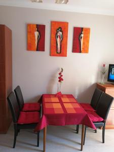 a dining room with a red table and two chairs at Apartment Gdańsk Wrzeszcz in Gdańsk