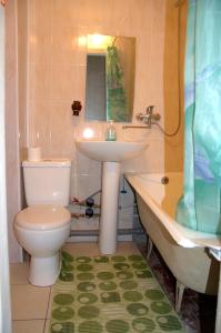 a bathroom with a sink and a toilet and a tub at Apartment Miorita in Chişinău