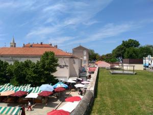 eine Gruppe von Tischen mit Sonnenschirmen neben einem Gebäude in der Unterkunft Room Tereza in Zadar