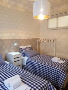 ヴィラ・ノヴァ・デ・ガイアにあるJanelas do Portoの- チェック済みのベッド2台(青と白のシーツ付)