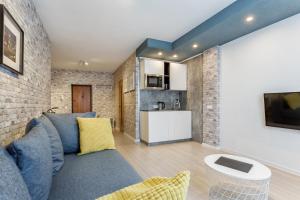 a living room with a blue couch and a kitchen at Minsk Apartment in Minsk