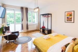 a bedroom with a large bed and a living room at City Side Up Exclusive in Belgrade