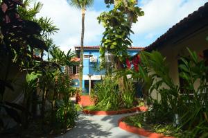 una casa con una palmera y un patio en Pousada Fragata - Arraial D Ajuda - Melhor Localização e Atendimento, en Arraial d'Ajuda