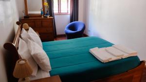 1 dormitorio con 1 cama azul y 1 silla azul en Apartamento Tavira, en Tavira