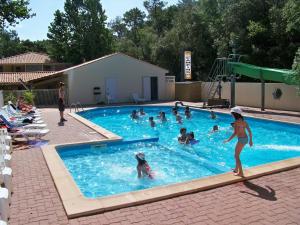 een groep mensen die in een zwembad spelen bij Camping Le Clos Des Pins in Longeville-sur-Mer