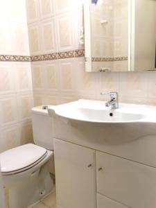 Baño blanco con aseo y lavamanos en Lisbon Woods House II, en Lisboa