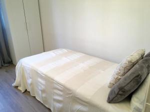 una cama blanca con almohadas en una habitación en Lisbon Woods House II, en Lisboa