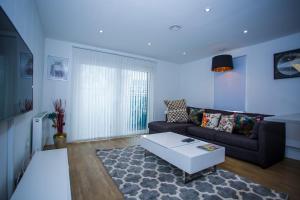 a living room with a couch and a coffee table at PRESTIGE 2 BED BALCONY APARTMENT in Abbey Wood