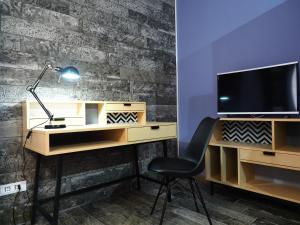 escritorio con monitor y silla en la habitación en Appartamento in villa en Caltanissetta