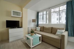 a living room with a couch and a tv at Ferienappartement-Moenchgut-14 in Ostseebad Sellin