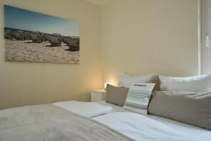 a bedroom with a bed and a picture of a beach at Ferienappartement-Moenchgut-14 in Ostseebad Sellin