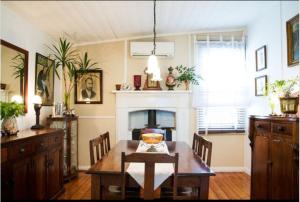 a dining room with a table and a fireplace at Sinnamons Cottage in Maldon