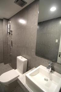 a bathroom with a sink and a toilet and a mirror at Z Pad Residences in Tacloban