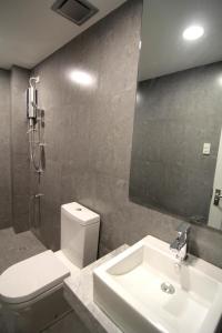 un bagno con lavandino, water e specchio di Z Pad Residences a Tacloban