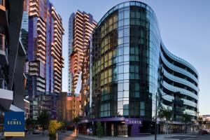 墨爾本的住宿－The Sebel Melbourne Docklands Hotel，一座高大的玻璃建筑,在城市里