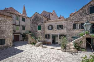 a courtyard of an old stone building with a staircase at House Heritage in Stari Grad