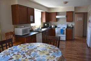a kitchen with wooden cabinets and a table with a table at North Coast Trail Backpackers Ltd in Port Hardy