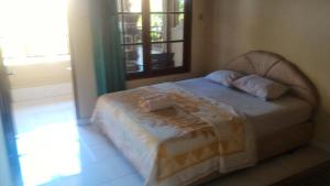 a bed with two pillows on it in a bedroom at Adus Beach Inn in Legian