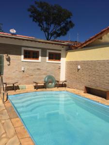 a swimming pool in front of a house at Villa Cottage Pousada in Monte Alegre do Sul