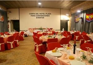 une salle de banquet avec des tables, des chaises rouges et un écran dans l'établissement Apartamentos Turisticos Casa Pastor, à Riaza
